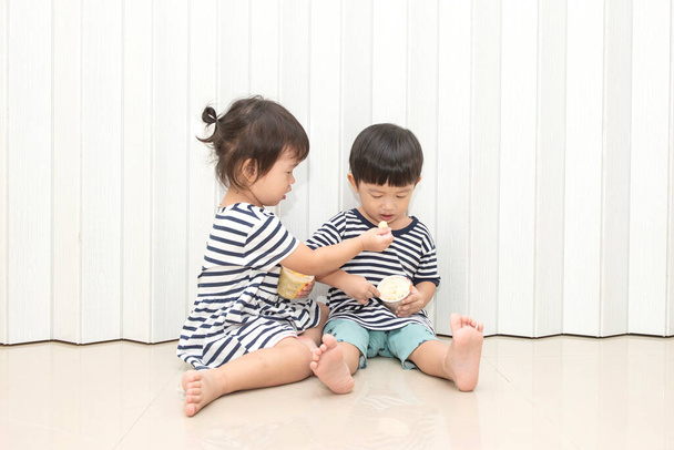 Tatlı küçük kız dondurmasını kardeşiyle paylaşıyor. - Fotoğraf, Görsel