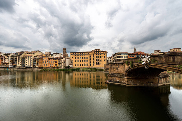 Флорентийский городской пейзаж, мост Санта-Тринита (XVI век) и река Арно, объект мирового наследия ЮНЕСКО. Тоскана, Италия, Европа - Фото, изображение