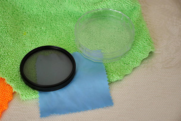 Limpieza de la lente de la cámara y las gafas de filtro con tela de microfibra, lente y mantenimiento del vidrio filtrante, - Foto, Imagen