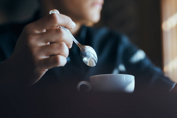 Cup of coffee on the table with white rice and a teaspoon of cafe mens hands. - 写真・画像