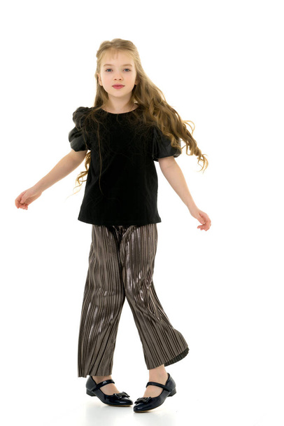 A cheerful little girl is dancing.The concept of a school of dance. - Φωτογραφία, εικόνα