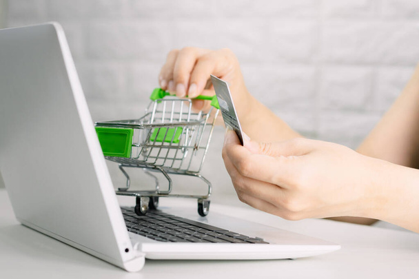 Hands holding credit card on the keyboard online shopping on laptop - Valokuva, kuva