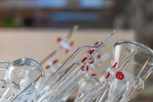 Diverse schone glasspaanders hangen aan de muur in een chemisch laboratorium voor farmaceutisch onderzoek voor medicijnontwikkeling - Foto, afbeelding