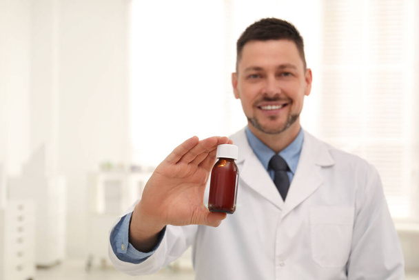 Professional pharmacist in drugstore, focus on hand with syrup - Photo, Image