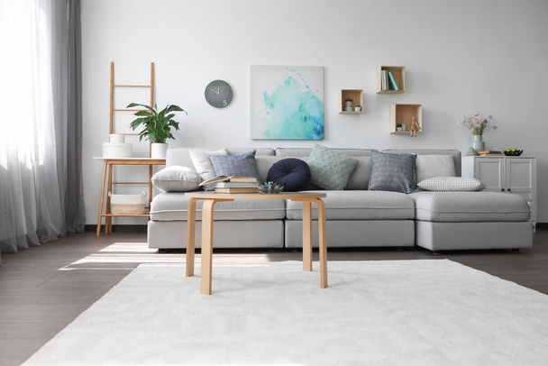 Elegant living room with comfortable sofa and wooden table. Interior design - Fotoğraf, Görsel