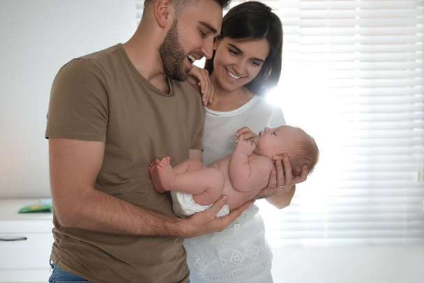 Happy couple with their newborn baby at home - Фото, изображение