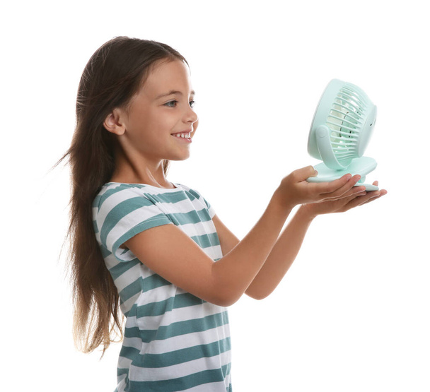 Little girl enjoying air flow from portable fan on white background. Summer heat - Foto, Imagem