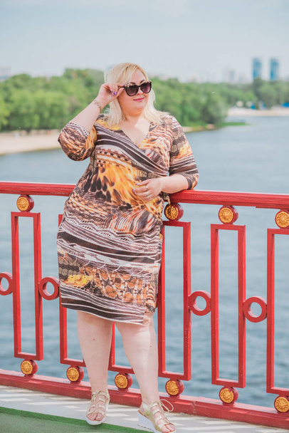 Een vrouw van plus size, Amerikaanse of Europese uitstraling wandelingen in de stad genieten van het leven. Een jonge dame met overgewicht, stijlvol gekleed in het centrum van de stad. Natuurlijke schoonheid - Foto, afbeelding
