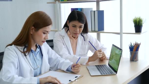 Two women doctors consultation with professional specialist diagnostics at hospital medicare treatment clinic. Doctor writing prescription for medical health care oncologist therapy using laptop.  - Footage, Video