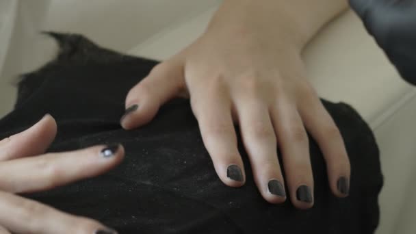 Mistr v černých latexových ochranných rukavicích namáčí štětec do trubice s černým lakem. Kosmetický salon, manikúra - Záběry, video