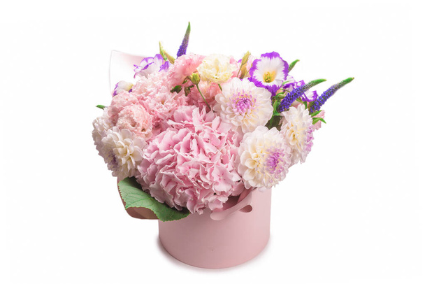 Bouquet de fleurs rose et violet dans une boîte rose isolée sur fond blanc.  - Photo, image