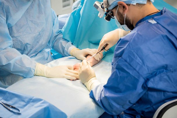 Chirurgiens dans la salle d'opération essayant de sauver la main des patients. - Photo, image