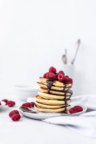 Tasty Pancakes. Stack of pancakes topped with chocolate and raspberry. Tasty breakfast - Fotoğraf, Görsel