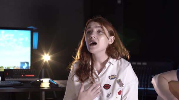 bella donna dai capelli rossi canta in uno studio di musica. Primo piano - Filmati, video