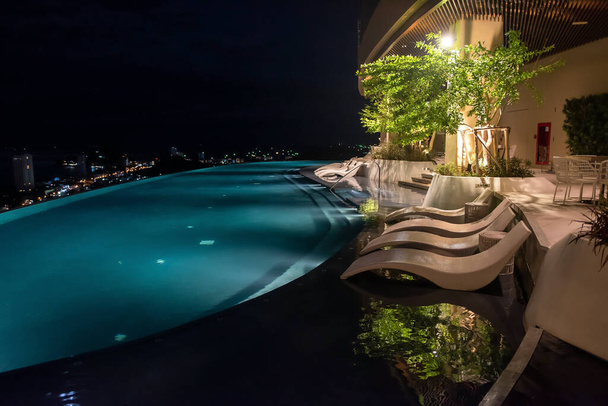 Luxusní bazén na střeše s noční světlo město s výhledem na moderní hotel. Odpočiňte si u bazénu. Skyline View Empty Nobody - Fotografie, Obrázek