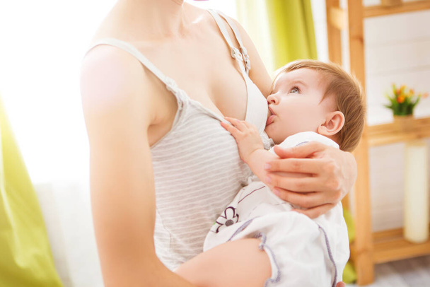 Mom breast feeding baby over window lighting - Foto, Bild