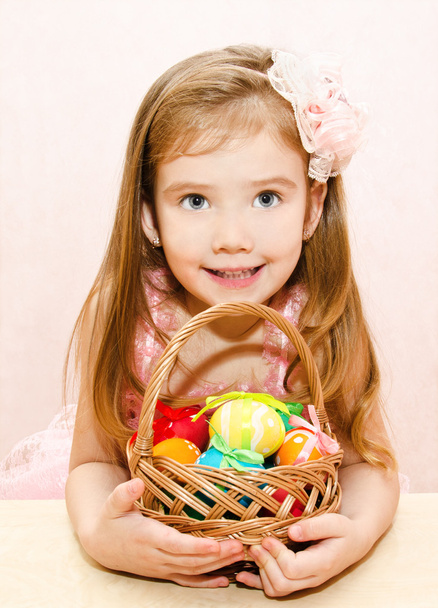 Little girl with basket full of colorful easter eggs - Фото, зображення