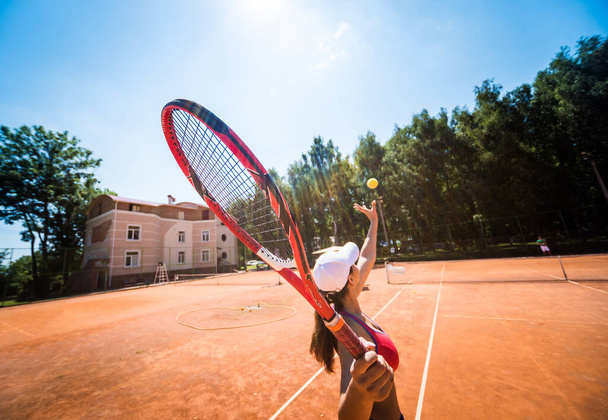 Young athletic woman playing tennis on the court. - Photo, image