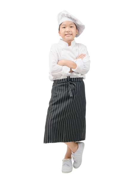 Ritratto di Happy bambina in uniforme da chef è stare in piedi e sorridere isolato su sfondo bianco. Kid chef Concept - Foto, immagini