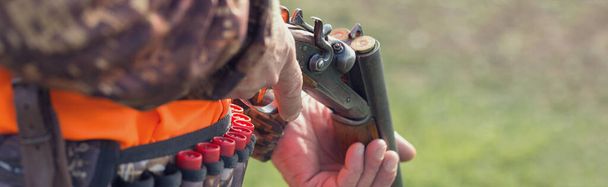 Hombre cazador en el campo rural con escopeta y mochila durante la temporada de caza - Foto, Imagen