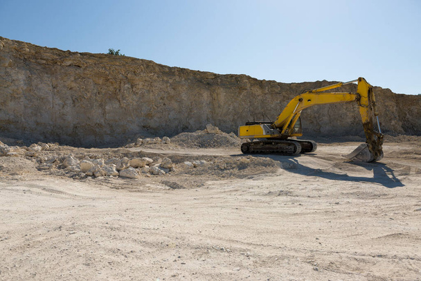 大規模な黄色の追跡掘削機は採石場で岩を採掘している. - 写真・画像