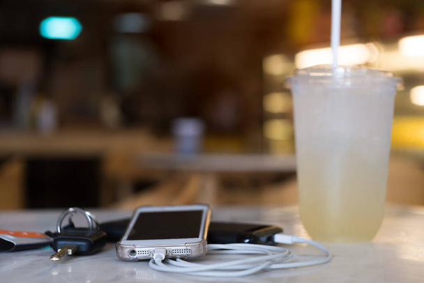 Carregamento de Smartphone com banco de energia com limonada e chaves - Foto, Imagem