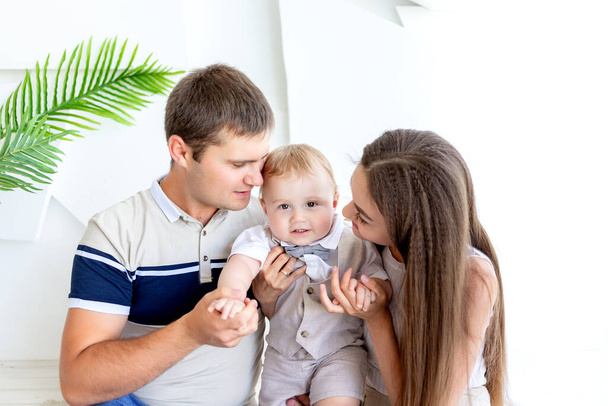 young mom and dad holding a child, parents with a child in a photo Studio, family day - Photo, Image
