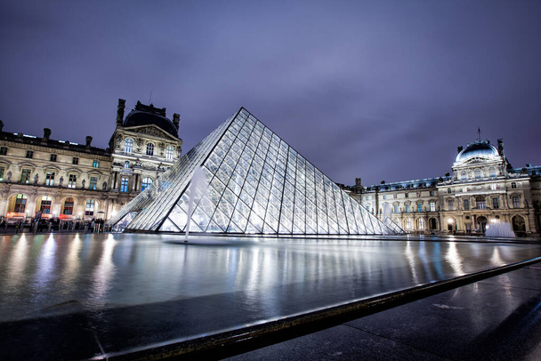 PARIS - TAMMIKUU 4: Louvren museo ja pyramidi yöllä 4. tammikuuta 2013. Louvre on yksi maailman suurimmista museoista Pariisissa. Lähes 35000 esihistoriasta 1800-luvulle on esillä 60.600 neliömetrin alueella - Valokuva, kuva