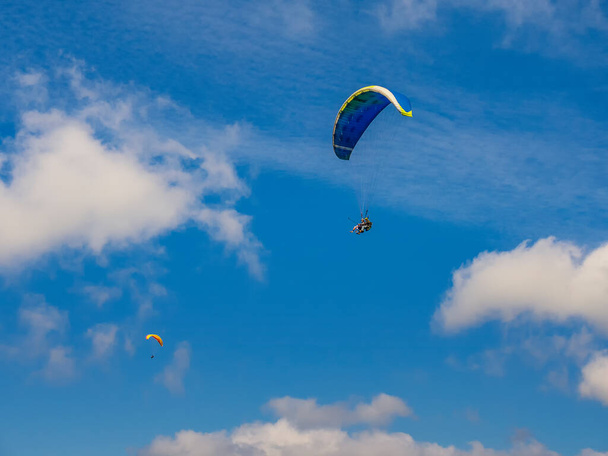 2020-08-23 Borzhava, Ukraine. Tandem paragliders in the sky. Typical tourist activity in Carpathian mountains - 写真・画像