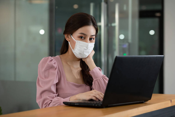Happy Asian business woman wearing face mask looking laptop working at modern office or Co-Working Space,Business Startup Concept - Foto, Imagem