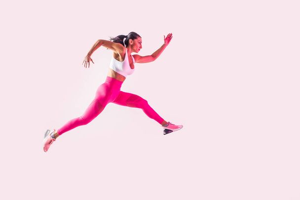 Athletic woman with fitness sportswear traning - Beautiful girl doing fitness in a studio - Фото, зображення