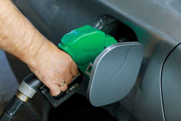 Man pumping gasoline fuel in car transportation at gas station - Фото, изображение
