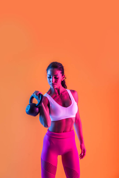 Athletic woman with fitness sportswear traning - Beautiful girl doing fitness in a studio - Фото, зображення