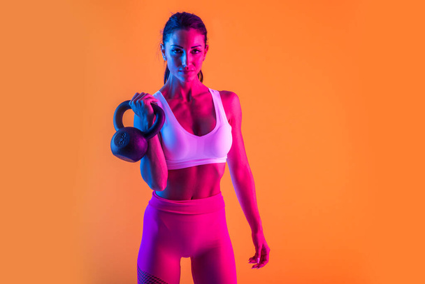 Athletic woman with fitness sportswear traning - Beautiful girl doing fitness in a studio - Foto, afbeelding