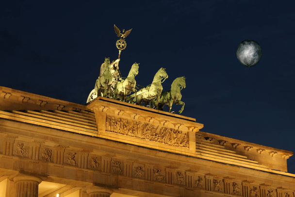 Berlin, Almanya 'daki Brandenburg Kapısı' nın tepesinde bronz at kadrili.  - Fotoğraf, Görsel