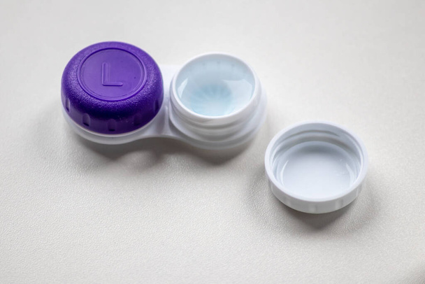 Contact lens container with contact lenses as optic alternative to glasses correct eyesight diseases like farsightedness and nearsightedness from a optician or eye doctor with medical hygiene concept - Fotografie, Obrázek