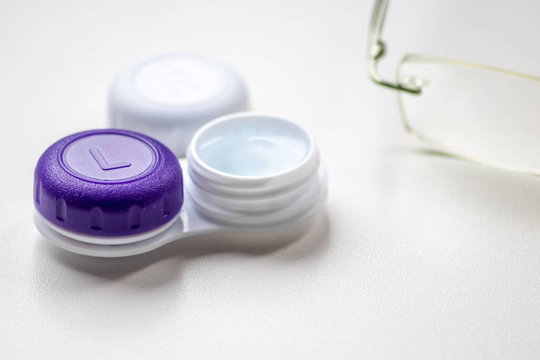 Contact lens container with contact lenses as optic alternative to glasses correct eyesight diseases like farsightedness and nearsightedness from a optician or eye doctor with medical hygiene concept - Photo, Image