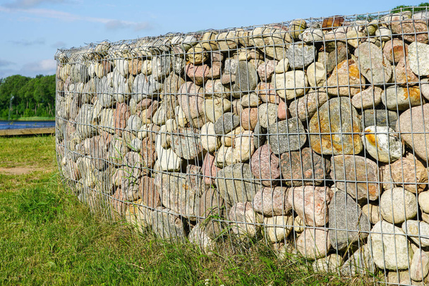 gabion fence wall from steel mesh with stones in rural area - Photo, Image