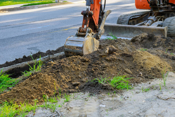 Pelle rétrocaveuse sur pelleteuse de travaux routiers travaillant à la construction dans la fosse d'excavation - Photo, image