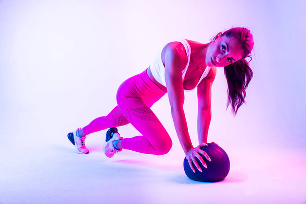 Athletic woman with fitness sportswear traning - Beautiful girl doing fitness in a studio - Foto, Imagen