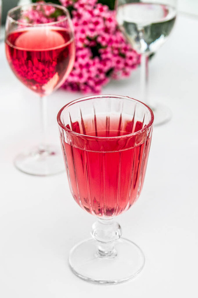 Pink drink in a glass. Pink flowers. - Photo, Image