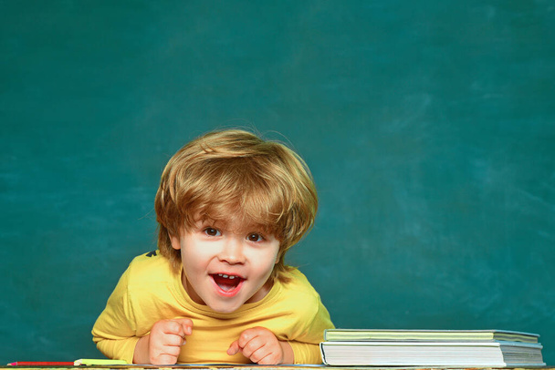 Funny little kid on blackboard. Back to school. Copy space. Child little preschool boy in a classroom. - Photo, image