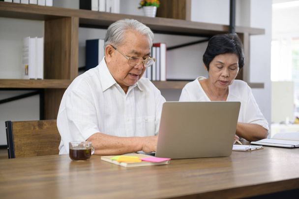 A happy senior Asian couple is spending time on surfing  the internet and talking with family on webcam,  retirement concept. - Fotoğraf, Görsel