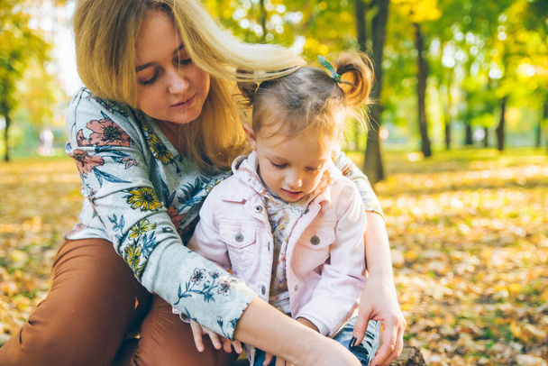 Mutter mit kleiner Kleinkind-Tochter spielt im Stadtpark - Foto, Bild