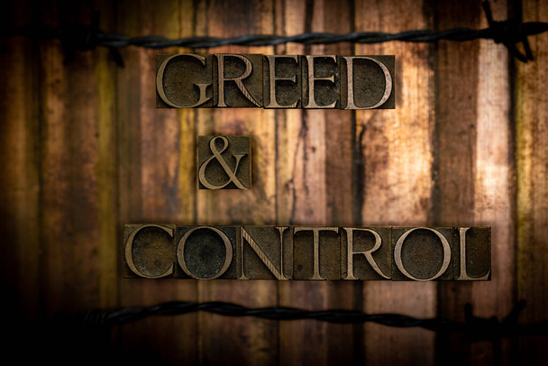 Greed and Control text formed by real authentic typeset letters with barbed wire on vintage textured grunge cobre and gold background - Foto, Imagem