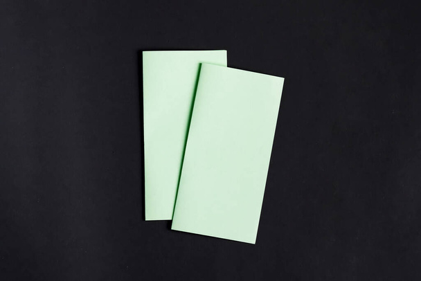 Mock-up grüne Vorlage Papier Broschüren oder Karte für Menütext oder andere Nachrichten auf schwarzem Hintergrund, Kopierraum. - Foto, Bild