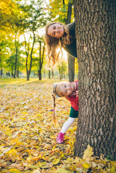Äiti tytär kurkistaa ulos puusta - Valokuva, kuva