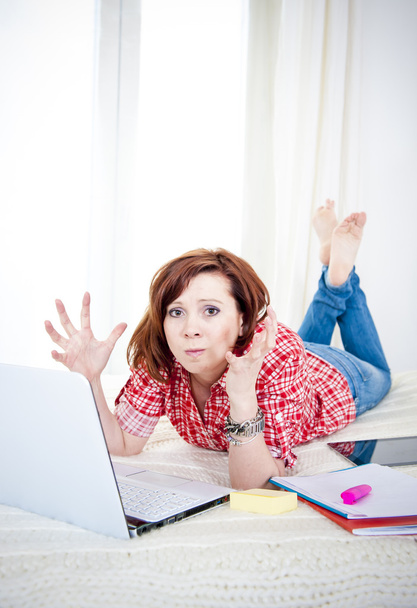 rood haar student, zakenvrouw liggen die op laptop werkt - Foto, afbeelding