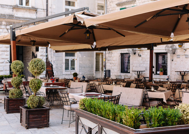 Cafe terrace with tables and chairs, large tents. Summer outdoor.  - Foto, immagini
