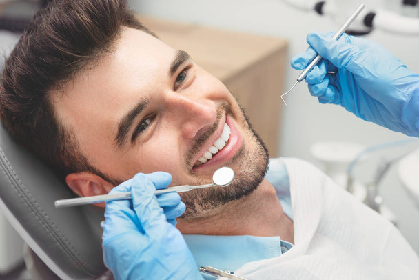 Man having teeth examined at dentists. Overview of dental caries prevention - Foto, imagen